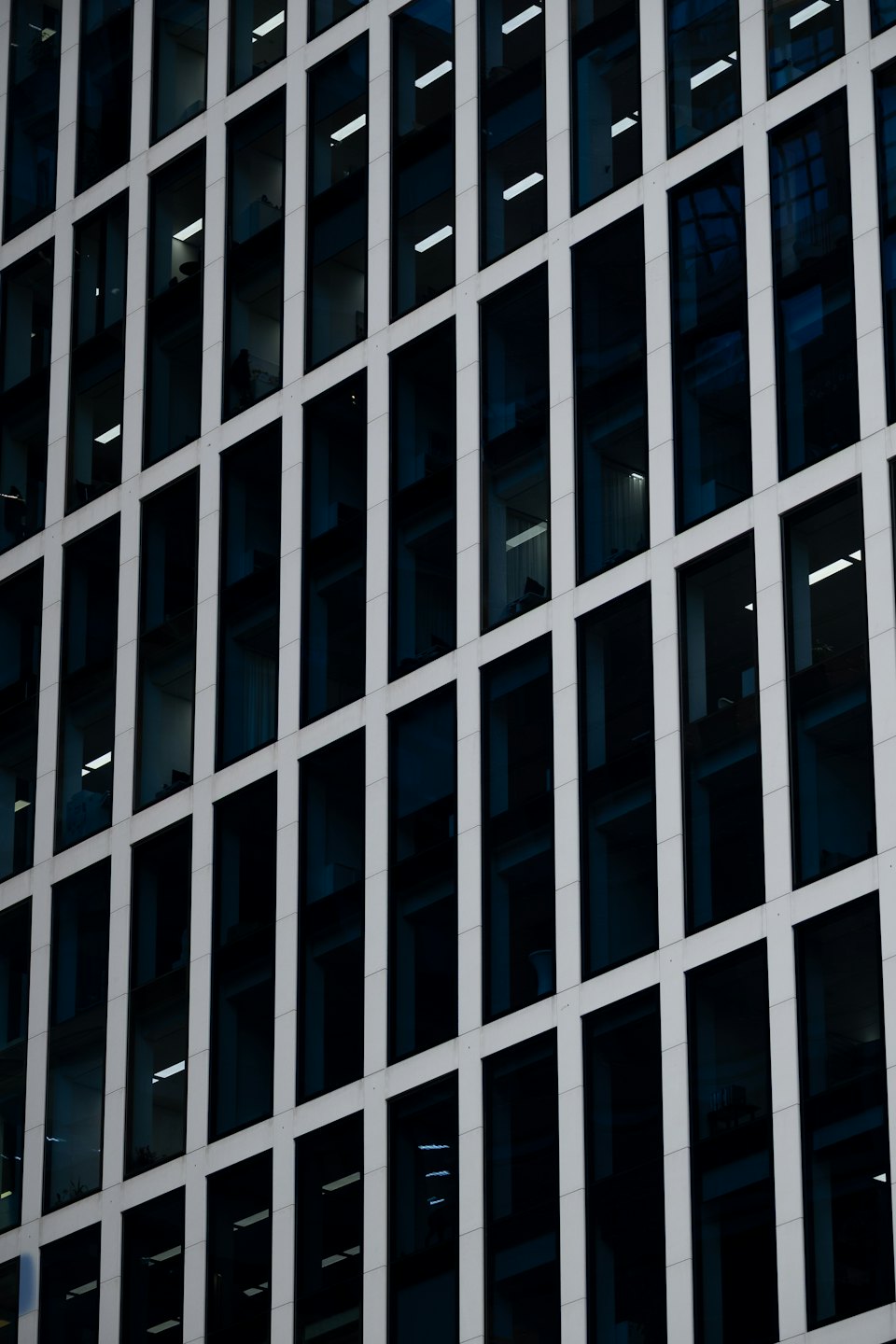 Modern office building facade with grey panels and dark windows.