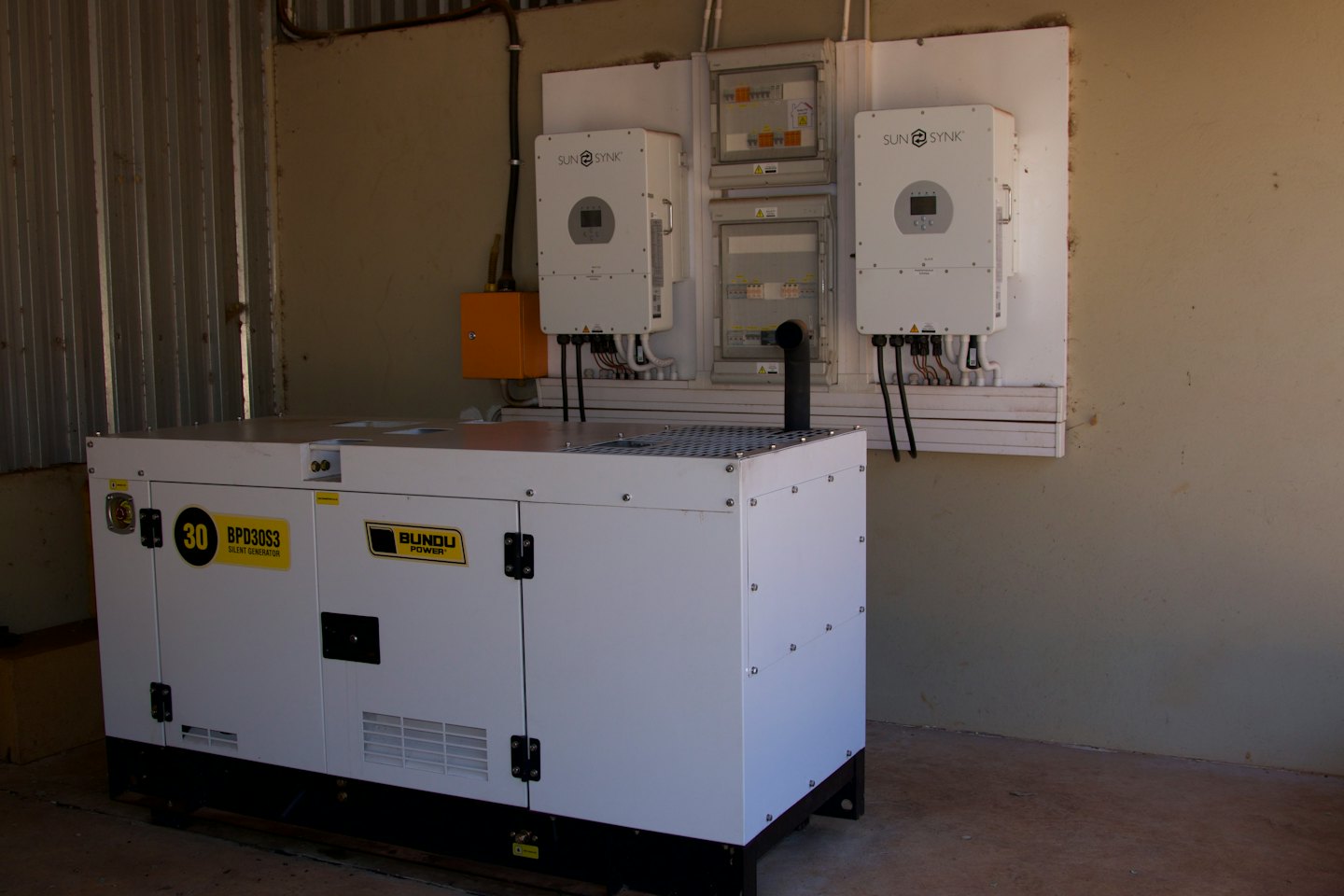 Industrial generator with solar inverters and distribution panels.